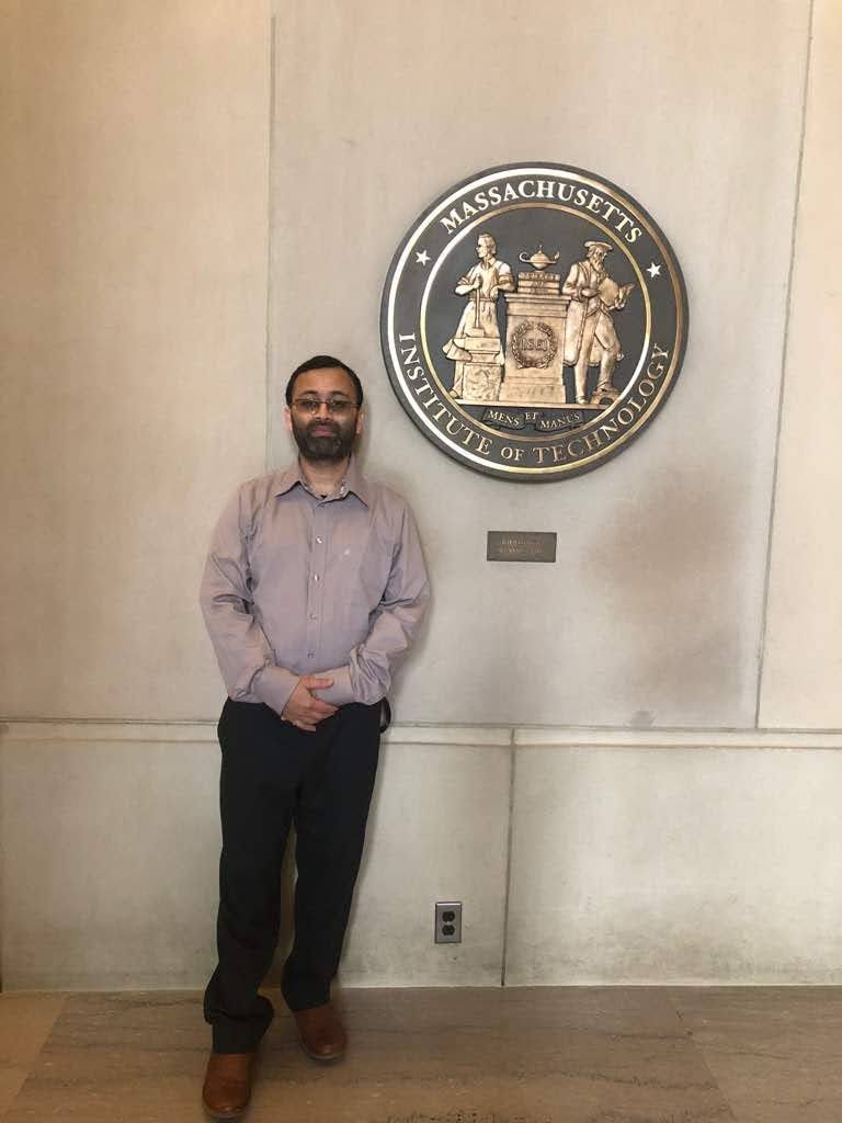 Abul Quasem Al-Amin beside the MIT seal